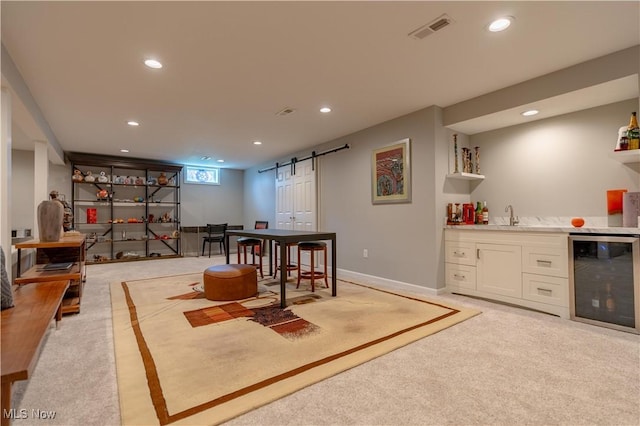 interior space featuring a barn door, beverage cooler, indoor wet bar, recessed lighting, and visible vents