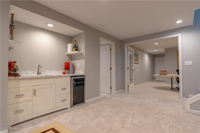 kitchen featuring open shelves, light carpet, beverage cooler, white cabinets, and a sink