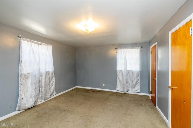 carpeted empty room with baseboards