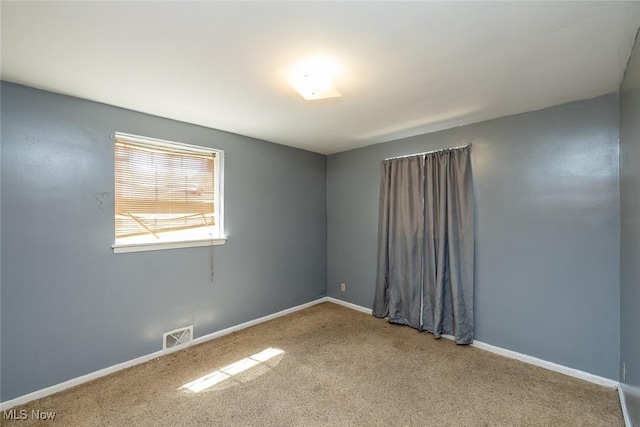 carpeted spare room with baseboards and visible vents