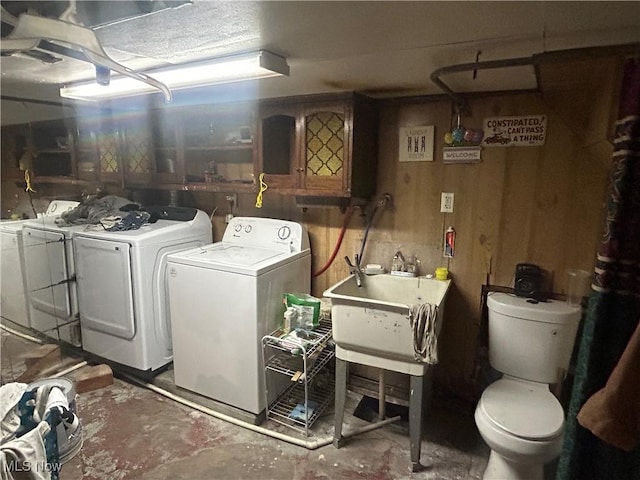 laundry room featuring wooden walls, laundry area, and washer and dryer