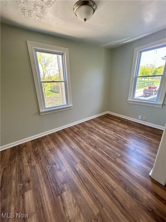 empty room with baseboards and wood finished floors