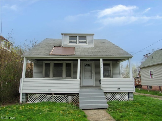 bungalow featuring covered porch, a shingled roof, and a front lawn