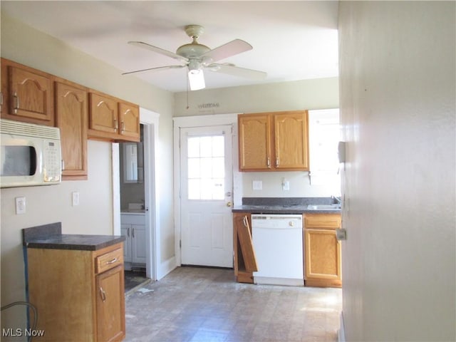 kitchen featuring dark countertops, ceiling fan, white appliances, and light floors