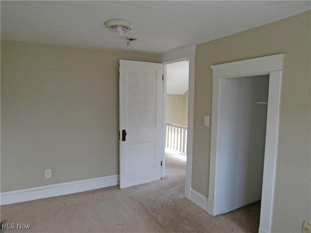 empty room with light colored carpet and baseboards