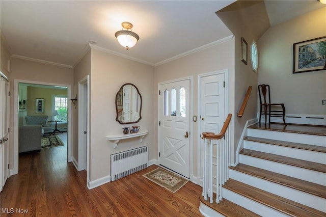 entryway with crown molding, radiator, stairs, wood finished floors, and baseboards