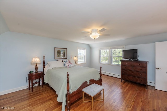 bedroom with baseboards, a baseboard heating unit, baseboard heating, and wood finished floors