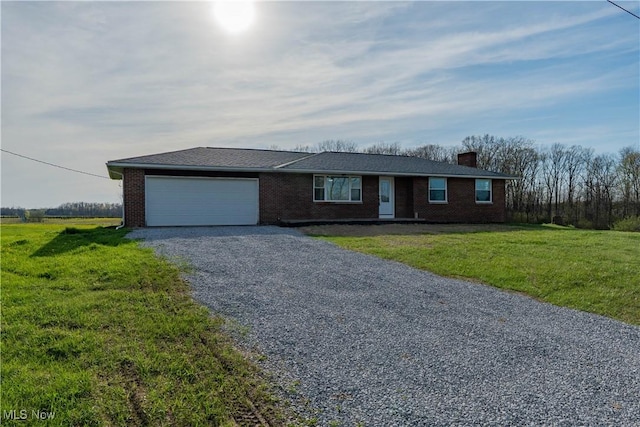 ranch-style home with an attached garage, brick siding, a chimney, and gravel driveway