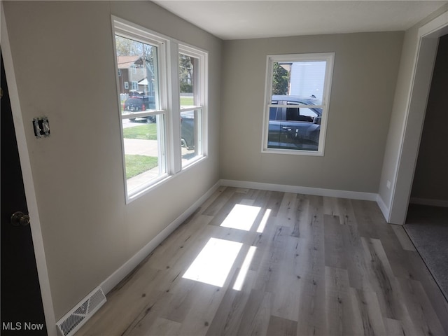 interior space featuring visible vents, light wood-style flooring, and baseboards