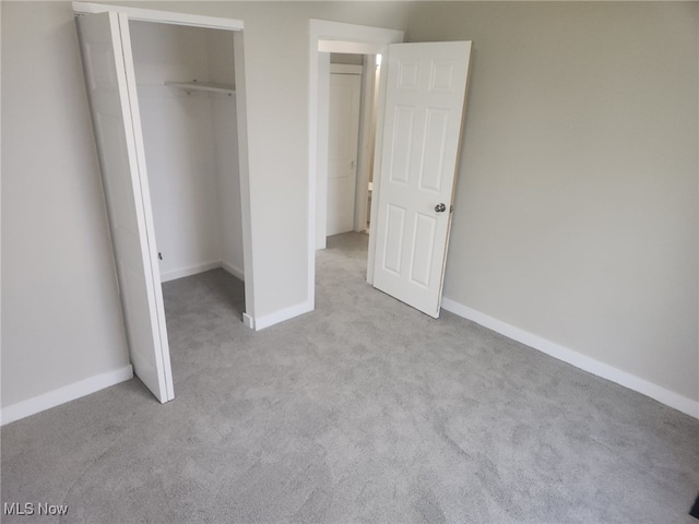 unfurnished bedroom with a closet, baseboards, and carpet flooring