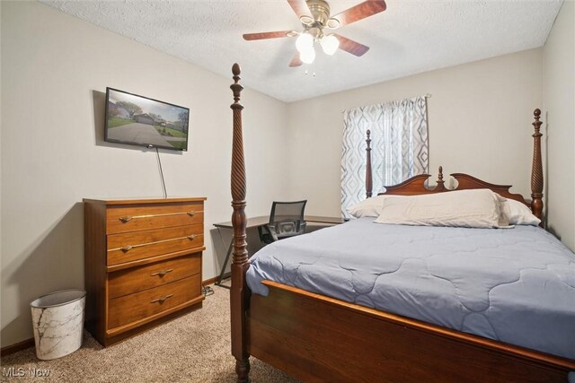 bedroom with baseboards, a textured ceiling, light carpet, and ceiling fan
