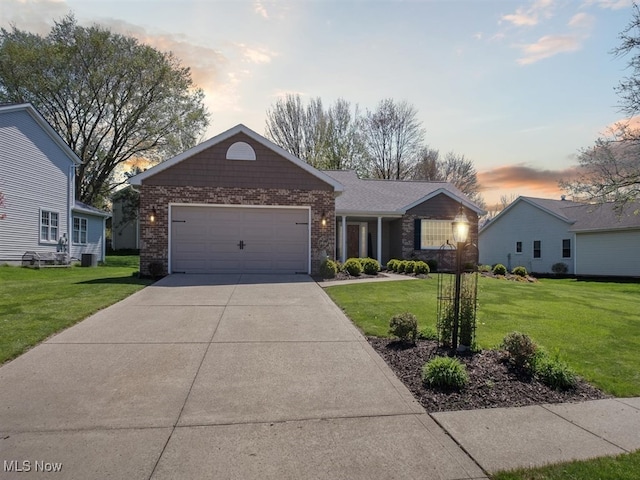 single story home featuring brick siding, an attached garage, driveway, and a front yard