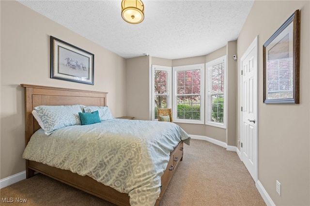 bedroom with carpet floors, a textured ceiling, and baseboards
