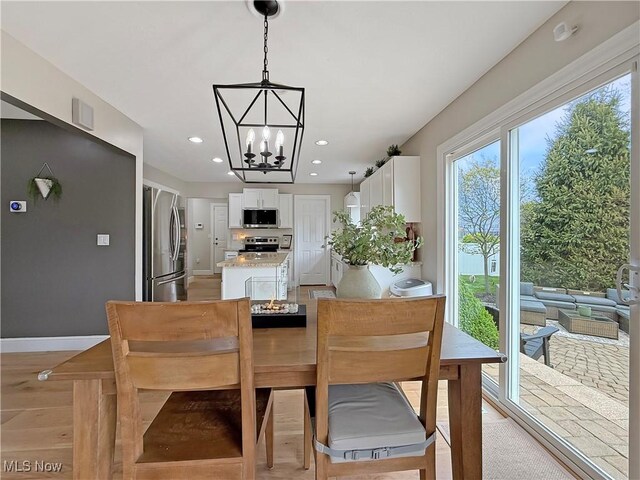 dining space featuring baseboards, recessed lighting, and a notable chandelier