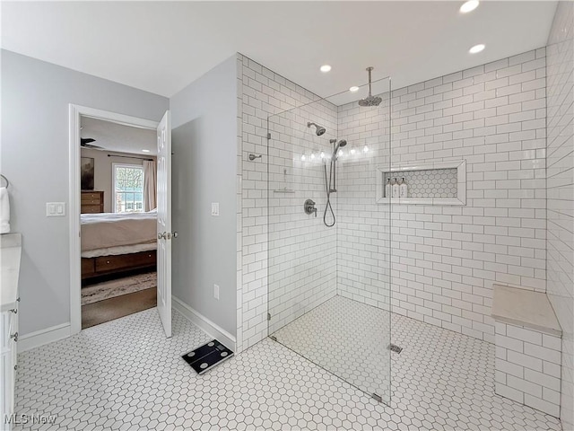 bathroom featuring recessed lighting, baseboards, a tile shower, and ensuite bath