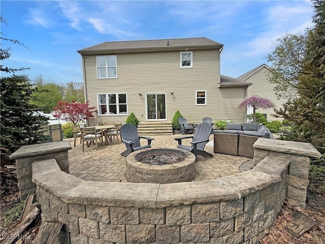 back of property featuring an outdoor living space with a fire pit and a patio area