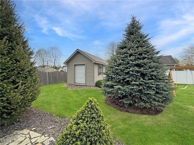 view of yard featuring fence, an outbuilding, and a shed