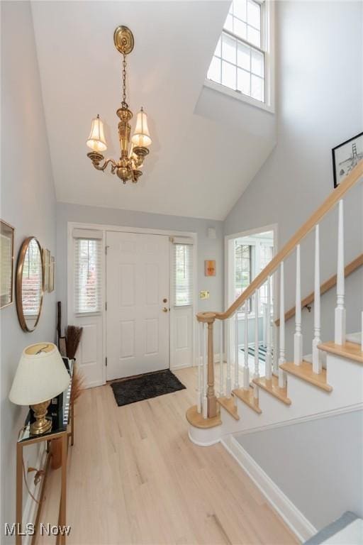 117 Royal Oak Dr, Aurora, OH 44202 - entryway with an inviting chandelier, high vaulted ceiling, stairway, and wood finished floors