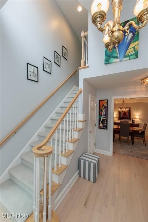 117 Royal Oak Dr, Aurora, OH 44202 - stairway featuring wood finished floors, baseboards, a high ceiling, recessed lighting, and a chandelier