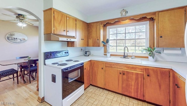 kitchen featuring ceiling fan, a sink, light countertops, under cabinet range hood, and white electric range