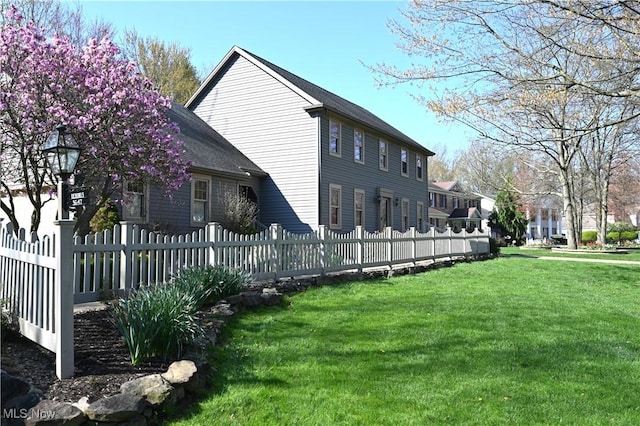 exterior space featuring fence private yard and a lawn