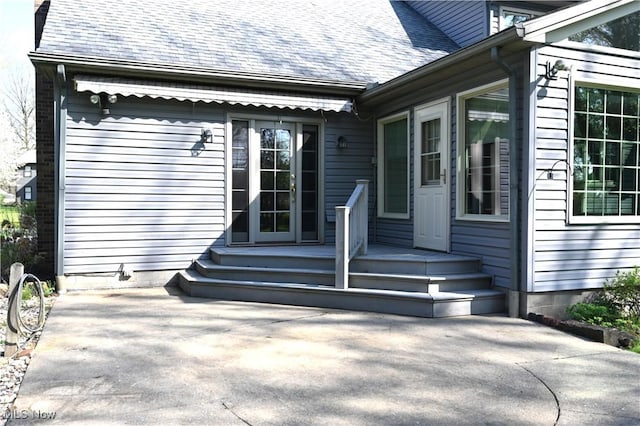property entrance featuring a shingled roof
