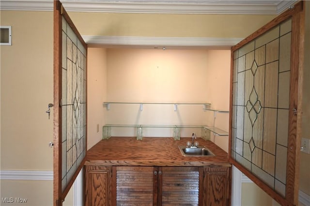 unfurnished office featuring crown molding, a sink, wet bar, and visible vents