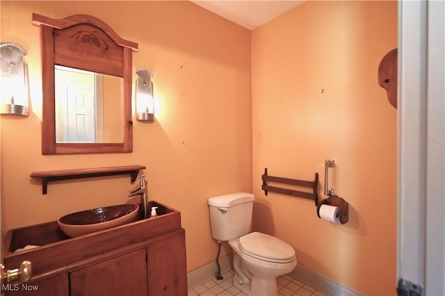 bathroom featuring toilet, baseboards, tile patterned flooring, and vanity