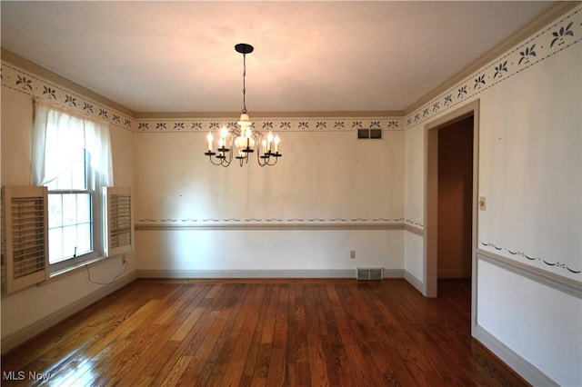 empty room featuring wood-type flooring, baseboards, visible vents, and an inviting chandelier