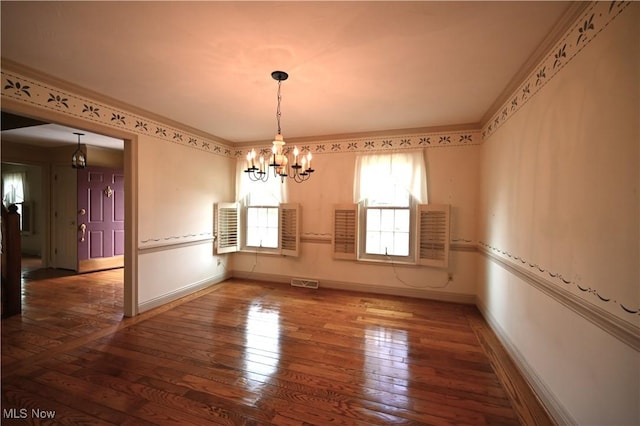 unfurnished dining area featuring an inviting chandelier, wood-type flooring, baseboards, and visible vents