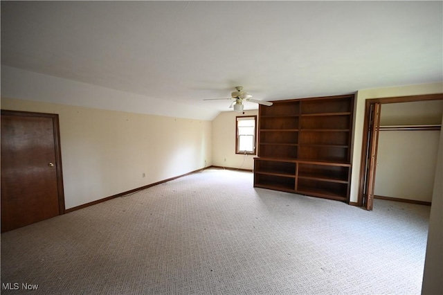 unfurnished bedroom with a ceiling fan, baseboards, a closet, lofted ceiling, and carpet flooring
