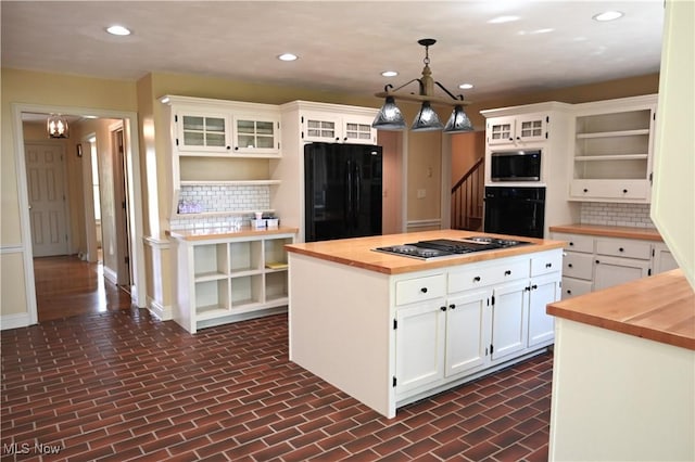 kitchen with tasteful backsplash, open shelves, black appliances, butcher block counters, and an inviting chandelier