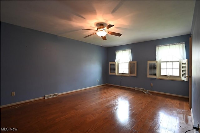 spare room featuring baseboards, a ceiling fan, wood finished floors, and visible vents