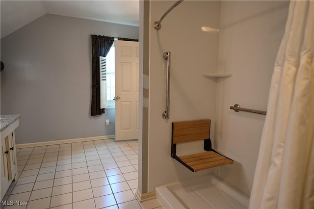 full bathroom featuring tile patterned flooring, baseboards, curtained shower, and vaulted ceiling