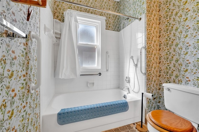 bathroom featuring shower / bathtub combination, toilet, and wallpapered walls