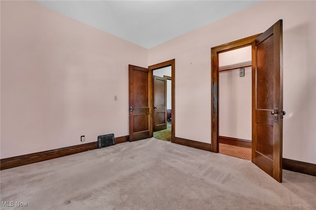 unfurnished bedroom with carpet flooring, baseboards, visible vents, and a closet