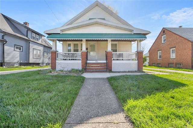 view of front of property featuring covered porch and a front lawn
