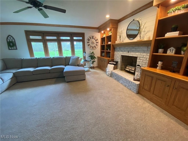 living room with light colored carpet, ornamental molding, a ceiling fan, and a fireplace