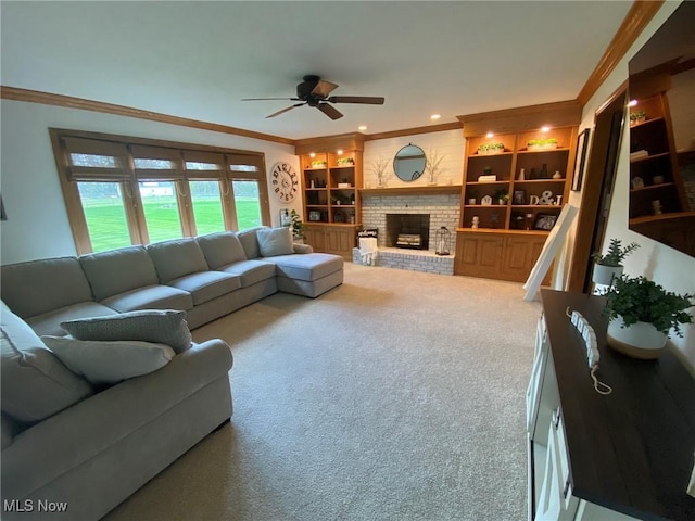living room featuring a ceiling fan, a fireplace, carpet floors, ornamental molding, and recessed lighting