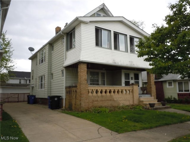 view of front facade with a chimney and a porch