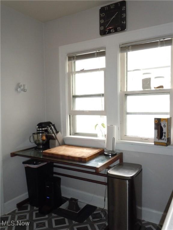 sitting room with baseboards and a healthy amount of sunlight