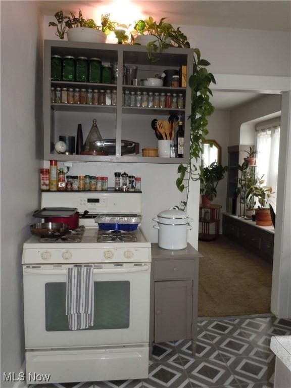interior space featuring tile patterned floors and white range with gas cooktop