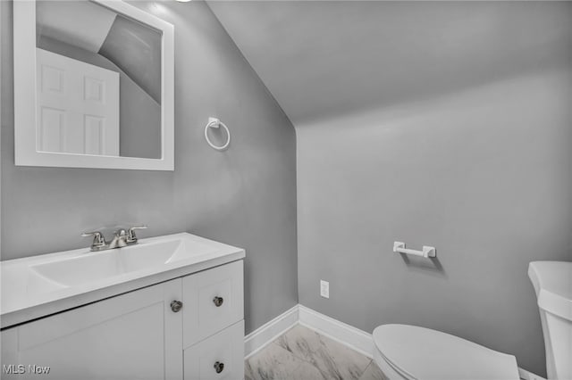 half bath with vanity, baseboards, toilet, and marble finish floor