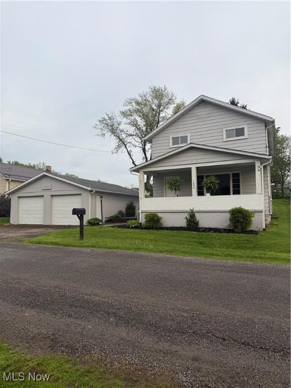 view of front of home featuring a detached garage and a front lawn