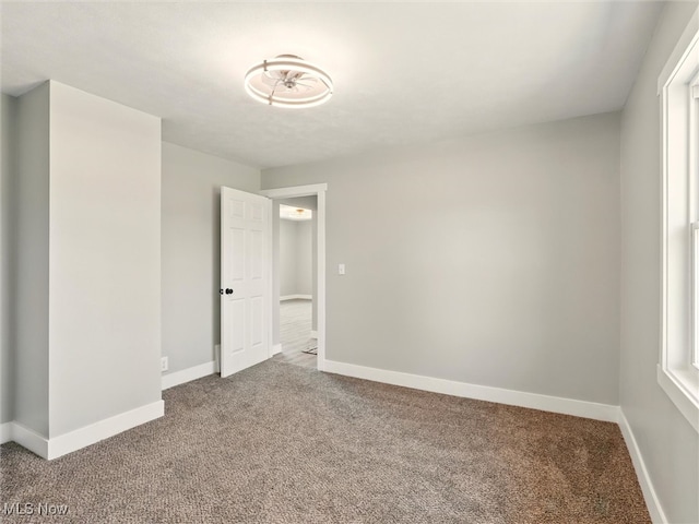 unfurnished bedroom featuring carpet floors and baseboards