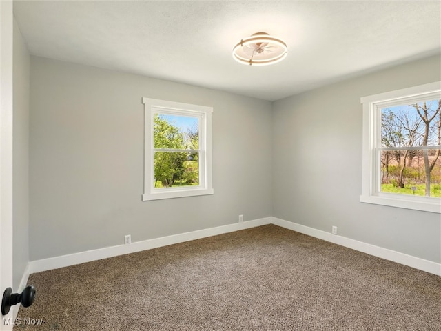 unfurnished room featuring carpet flooring, baseboards, and a healthy amount of sunlight
