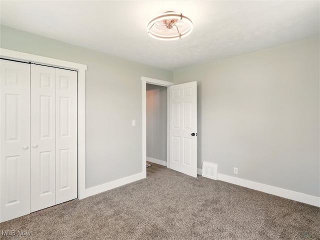 unfurnished bedroom featuring baseboards, carpet flooring, visible vents, and a closet