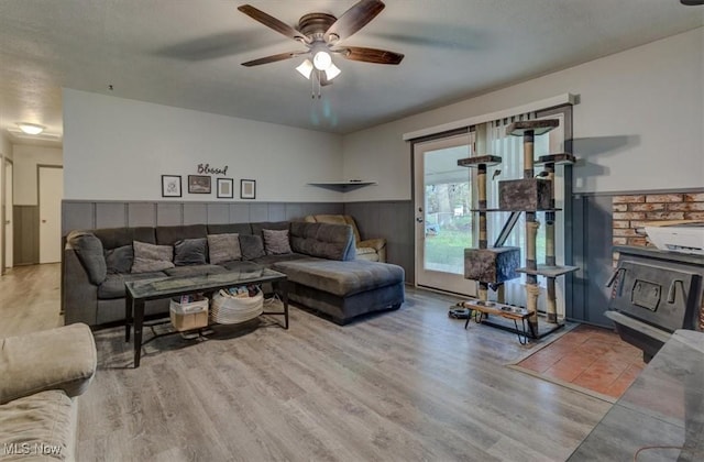 living room featuring a ceiling fan, wainscoting, and wood finished floors
