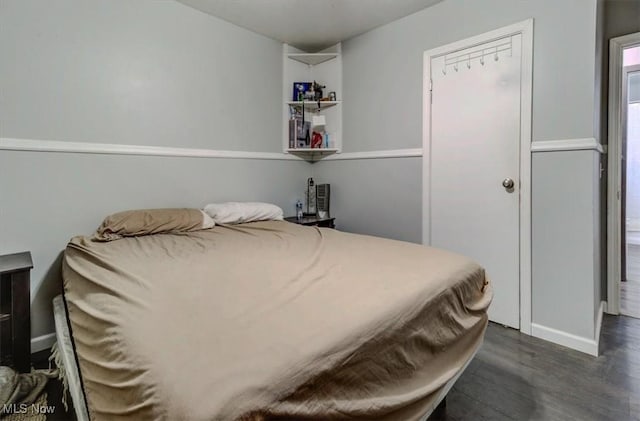 bedroom featuring baseboards and dark wood-style flooring