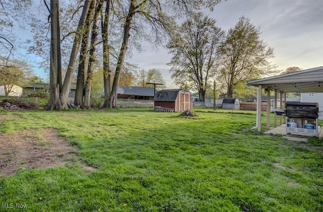 view of yard with a storage shed, an outbuilding, and a fenced backyard